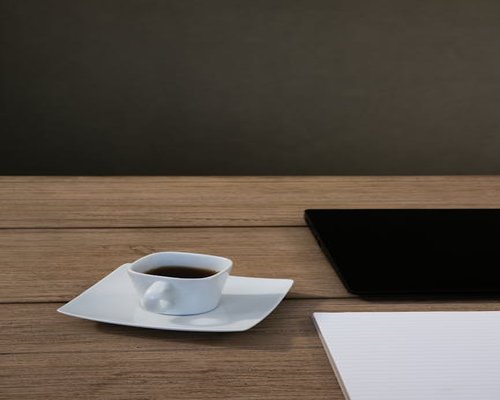 Coffee cup and tablet on a wooden table