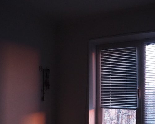 Window blind half closed modifying the light in a room