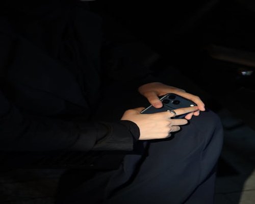 Person holding a smartphone in dim light